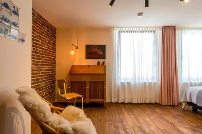 a bedroom with a bed and a desk and a window at Friday Gent, Exclusive Charming Guesthouse in Ghent