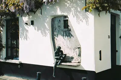 a person sitting on a window sill of a building at Friday Gent, Exclusive Charming Guesthouse in Ghent