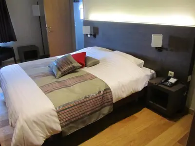 a bedroom with a large bed with two pillows on it at Hotel Klein Nederlo in Vlezenbeek
