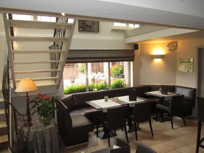 a restaurant with two tables and a couch and chairs at Hotel Klein Nederlo in Vlezenbeek
