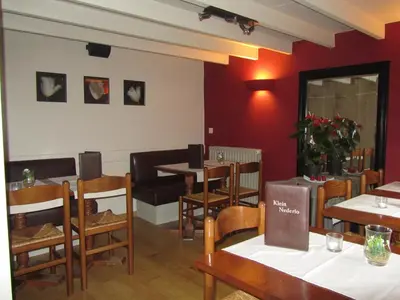 a restaurant with tables and chairs and red walls at Hotel Klein Nederlo in Vlezenbeek