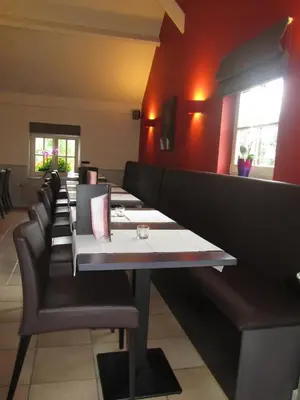 a row of tables and chairs in a restaurant at Hotel Klein Nederlo in Vlezenbeek