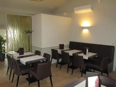 a restaurant with tables and chairs in a room at Hotel Klein Nederlo in Vlezenbeek