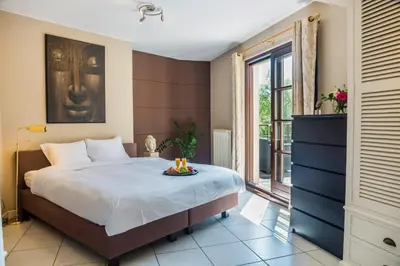 a bedroom with a large bed and a window at Brussels Expo Terrace Residence in Wemmel