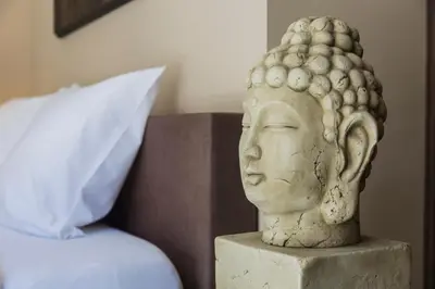 a statue of a head sitting next to a bed at Brussels Expo Terrace Residence in Wemmel