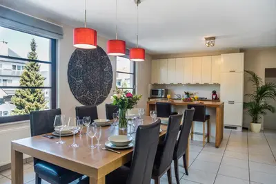 a kitchen and dining room with a table and chairs at Brussels Expo Terrace Residence in Wemmel
