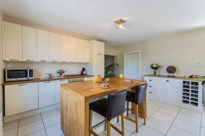 a large kitchen with a wooden table and chairs at Brussels Expo Terrace Residence in Wemmel
