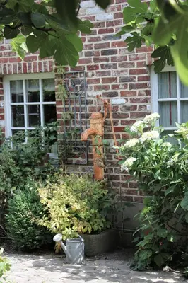 a brick building with a water fountain on the side of it at De Volle Maan in Sint-Lievens-Houtem