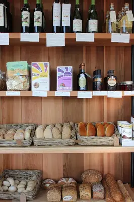 a shelf filled with lots of different types of bread at De Volle Maan in Sint-Lievens-Houtem