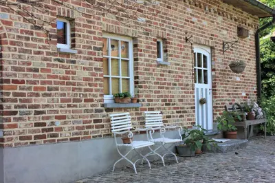 two chairs sitting outside of a brick building at De Volle Maan in Sint-Lievens-Houtem