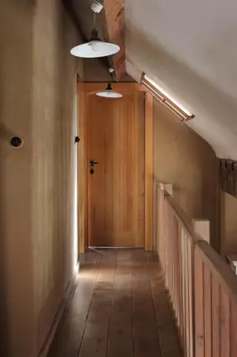 a hallway with a wooden door and a stairwell at De Volle Maan in Sint-Lievens-Houtem