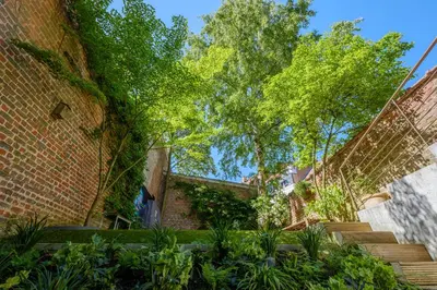 a brick building with stairs and trees in the background at 1bd apartment with garden Brugmann area in Brussels