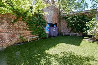 a garden with two benches and a brick wall at 1bd apartment with garden Brugmann area in Brussels