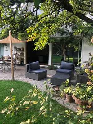 a patio with two couches and an umbrella at Villa Plagniau in Rixensart