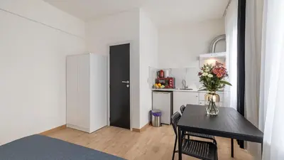 a kitchen with a table with a vase of flowers on it at Albert gare du Midi 31 in Brussels