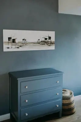 a bedroom with a blue dresser and tables and chairs at Charmeverblijf Juliette in Kasterlee