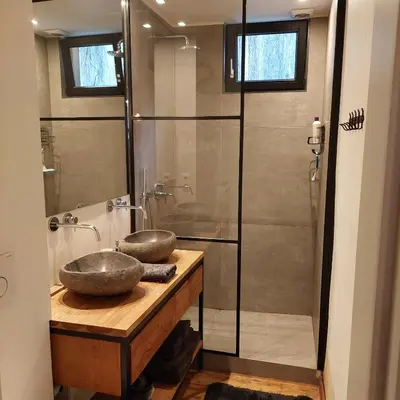 a bathroom with a shower with two sinks on a wooden counter at Plezantwerpen, Huize Amoras in Antwerp