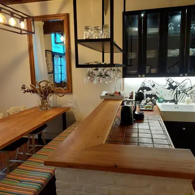 a kitchen with a large wooden table and a sink at Plezantwerpen, Huize Amoras in Antwerp