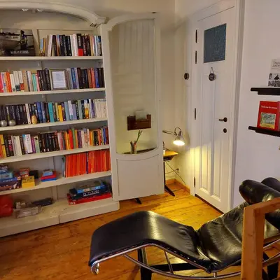 a living room with a book shelf filled with books at Plezantwerpen, Huize Amoras in Antwerp