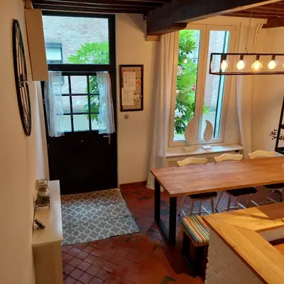 a kitchen and dining room with a table and windows at Plezantwerpen, Huize Amoras in Antwerp