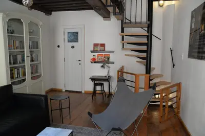 a living room with a spiral staircase and a table at Plezantwerpen, Huize Amoras in Antwerp