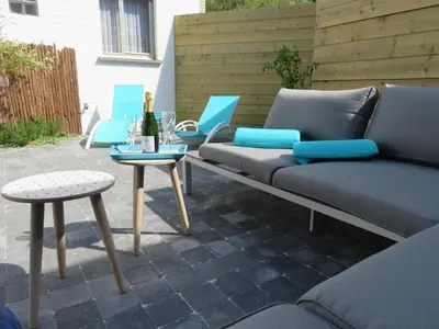 a patio with a couch and chairs and a table at Lovely Guesthouse Lier in Lint
