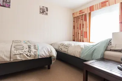 a bedroom with two beds and a table and a window at Lovely Guesthouse Lier in Lint
