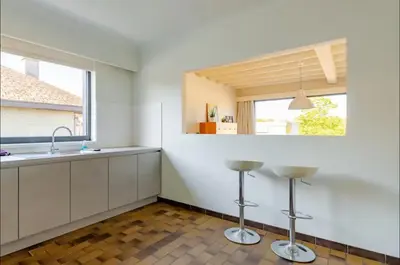 a kitchen with white cabinets and a sink and a window at Appartement224 in Grimbergen