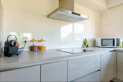a white kitchen with a sink and a microwave at Appartement224 in Grimbergen