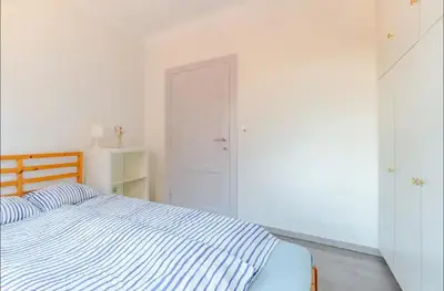 a bedroom with a blue and white bed and a door at Appartement224 in Grimbergen