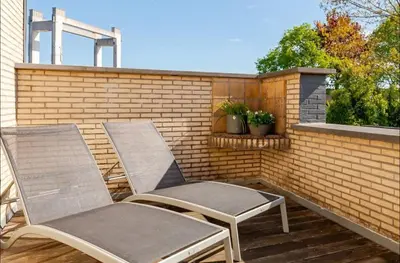 two chairs on a patio with a brick wall at Appartement224 in Grimbergen