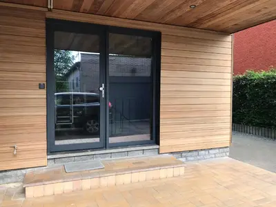 a glass door of a house with a car in it at Appartement224 in Grimbergen