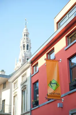 a colorful building with a clock tower in the background at Leuven City Hostel in Leuven