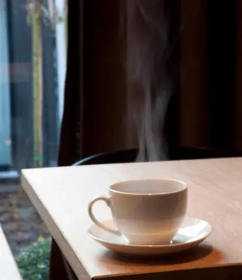 a cup of smoke sitting on a table with a saucer at B&B A Côté du Cinquantenaire in Brussels
