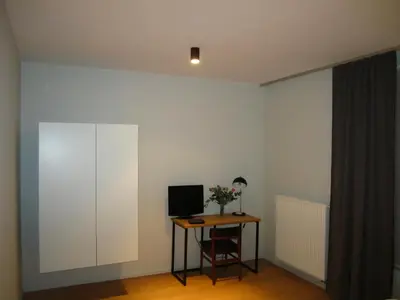 a room with a desk and a computer on a table at B&B A Côté du Cinquantenaire in Brussels