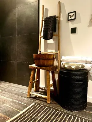a wooden rocking chair sitting in a room at AuxiliumWellness Get Back to Serenity in Grobbendonk