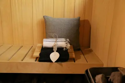 a wooden bench with a pillow and a key on it at AuxiliumWellness Get Back to Serenity in Grobbendonk