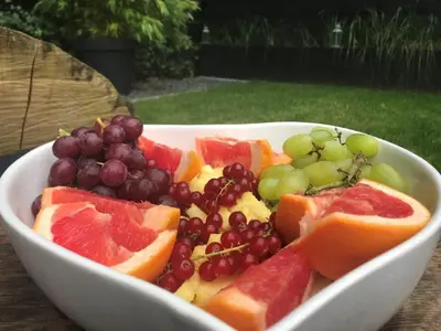 a white bowl filled with grapes and fruit at AuxiliumWellness Get Back to Serenity in Grobbendonk