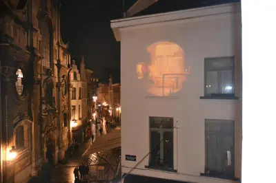 a building with a skull on the side of it at night at Olives in Brussels