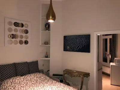 a bedroom with a bed and a table and a window at Olives in Brussels