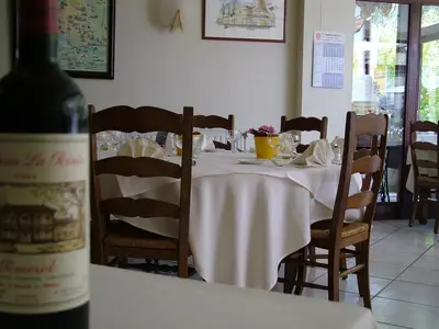 a table with a bottle of wine sitting on a table at Alsput Hotel in Halle