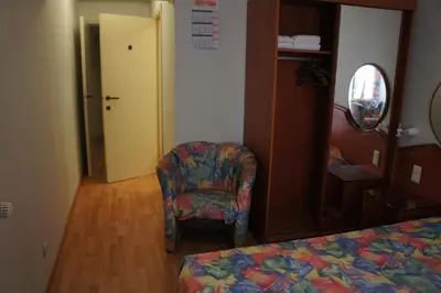 a room with a bed and a chair and a door at Alsput Hotel in Halle
