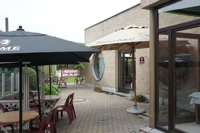a patio with tables and umbrellas outside of a restaurant at Alsput Hotel in Halle