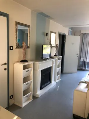 a living room with a tv and white cabinets at Guesthouse De Witte Merel Deluxe in Tessenderlo