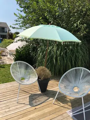 two chairs and an umbrella on a wooden deck at Guesthouse De Witte Merel Deluxe in Tessenderlo