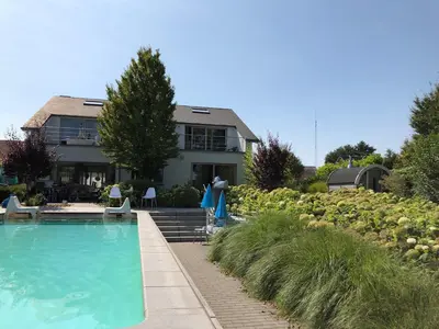 a house with a swimming pool in front of a house at Guesthouse De Witte Merel Deluxe in Tessenderlo