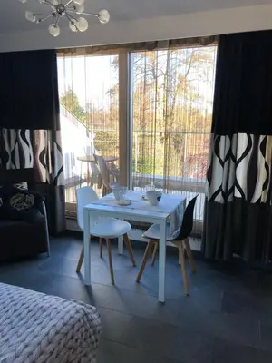 a white table and chairs in a room with a window at Guesthouse De Witte Merel Deluxe in Tessenderlo