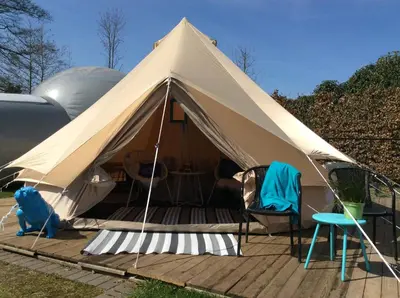 a canvas tent with chairs and a table at Guesthouse De Witte Merel Deluxe in Tessenderlo