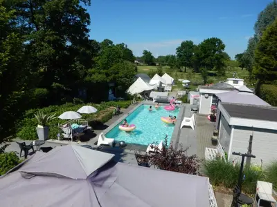 an overhead view of a swimming pool with people in it at Guesthouse De Witte Merel Deluxe in Tessenderlo