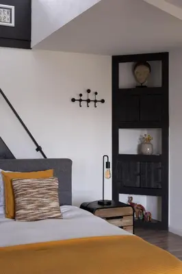 a bedroom with a large bed with a yellow blanket at B&B De Joker in Turnhout